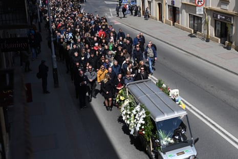 A large group of mourners follow a vehicle with flowers on it during a funeral procession for Damian Soból, an aid worker who was killed in an Israeli strike in Gaza, in his home town of Przemysl, Poland, on Saturday.