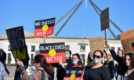 Black Lives Matter protesters hold placards outside parliament house in Canberra