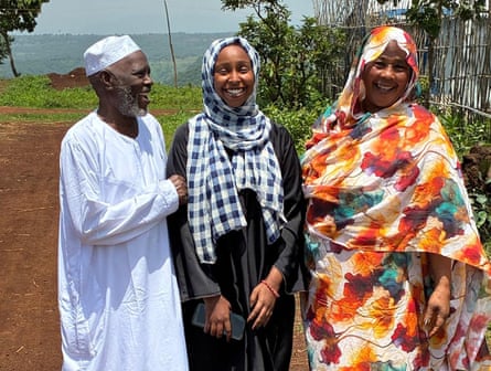 A man and two women all smile