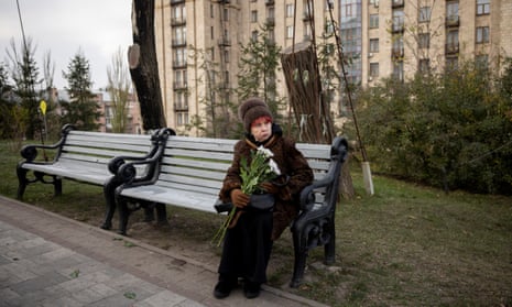 A woman holds flowers while sitting on a bench