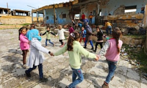 Children playing the shelled ruin of their school in western Idlib