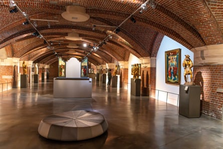 Paintings and sculptures in a vaulted basement.