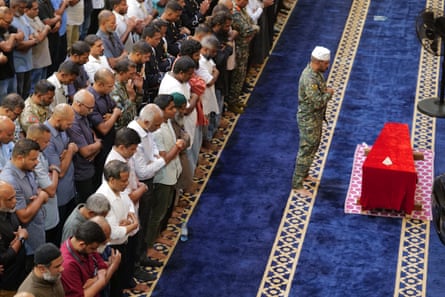 Maldivian president Mohamed Muizzu and national defence force members pray in front of the remains of military diver Mohamed Mahudhee, who died during the search and rescue operation for the Italian divers