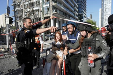 APTOPIX Israel Iran Mideast WarsA woman is evacuated from the site of a direct hit from an Iranian missile strike in Ramat Gan, Israel, Thursday, June 19, 2025. (AP Photo/Oded Balilty)