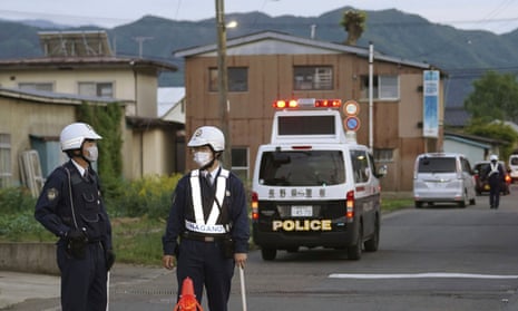 Police officers standing guard on a street leading to the building in Nagano where the suspect was holed up