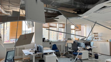 Interior image of an office where the ceiling is falling in and the windows are broken