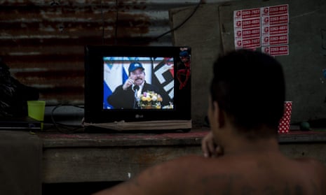 A man watches a television as President Daniel Ortega appears during a broadcast in Managua, Nicaragua, on Wednesday. He boasted that Nicaraguans ‘haven’t stopped working’.