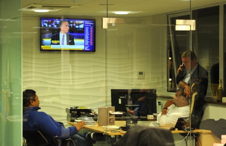 Harry Redknapp chats on his phone while keeping an eye on Sky Sports News with QPR’s owners on transfer deadline day in September 2014.