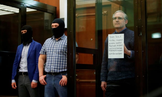 Пол Уилън държи знак, докато стои в клетка на обвиняемите по време на изслушването на присъдата му в Москва, Русия, на 15 юни 2020 г.