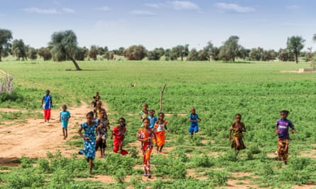 A group of children running across the savannah in Matam, Senegal