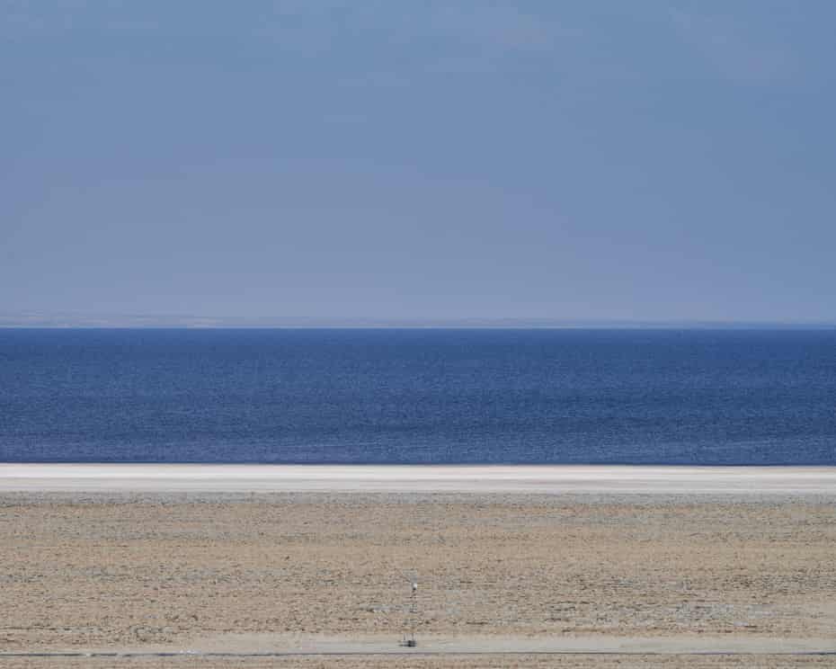 a view of the horizon with land, sea and sky