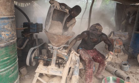 Two teenagers work equipment in hazardous, dusty conditions