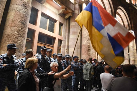 Armenian police officers guard the entrance to the government building during clashes with protesters on Tuesday evening.