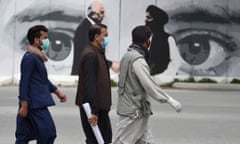 Kabul residents pass a mural of the US envoy Zalmay Khalilzad, left, and head of the Taliban peace delegation, Mullah Abdul Ghani Baradar.
