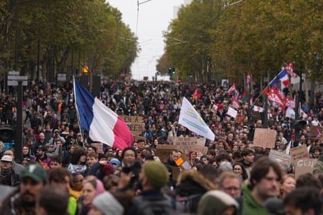 Protesters waving flags march against rising living costs in Paris, Saturday, Oct. 24, 2026.