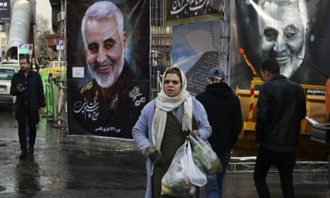 Pedestrians walk past banners of Iranian general Qassem Suleimani in Tehran