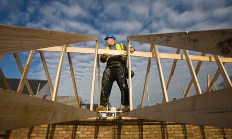 A worker helps construct housing on a Bellway building site