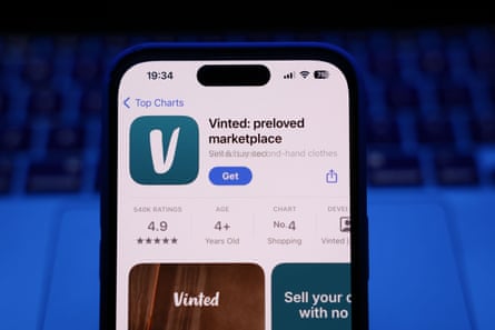 A laptop keyboard and Vinted on App Store displayed on a phone screen