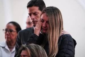 A man puts his hand on the shoulder of a woman in tears