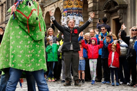Performer Herbie Treehead gets the public to volunteer to be his pantomime horse on the Royal Mile.