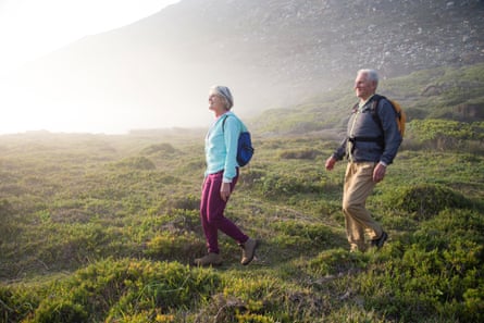 Senior couple walking outdoors togetherSenior couple hiking outdoors together on a coastal path near the sea