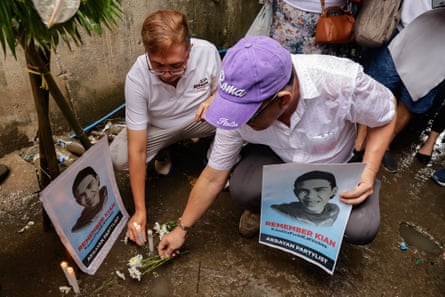Randy delos Santos (right) lays flowers in August at the sight where his nephew Kian delos Santos was shot and killed by police eight years ago in Caloocan City, Metro Manila