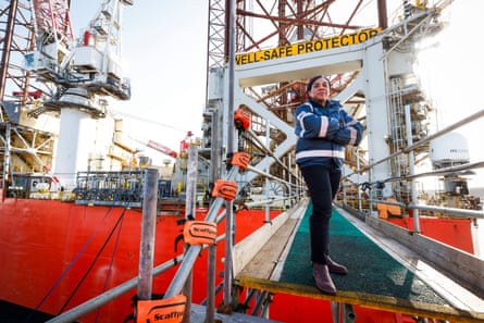 Kemi Badenoch stands on a gangway at an oil rig structure in a harbour.