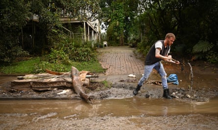 Lismore resident Eli Roth clears mud and debris from a drain outside his house