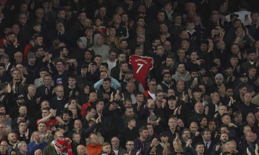 A supporter holds up Cristiano Ronaldo’s shirt during the minute’s applause at Anfield.