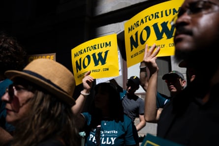 People hold yellow Moratorium Now signs