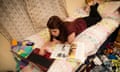 A young woman university student lying on her bed studying working reading writing on laptop in messy untidy bedroom at home UK<br>DRF2PB A young woman university student lying on her bed studying working reading writing on laptop in messy untidy bedroom at home UK
