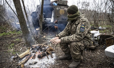 A Ukrainian soldier tries to warm up on the frontline, in Donetsk Oblast, Ukraine on November 28, 2022.