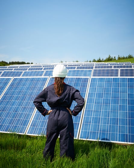 Female engineer looking at solar panel farm. Maintaining a photovoltaic power station.
