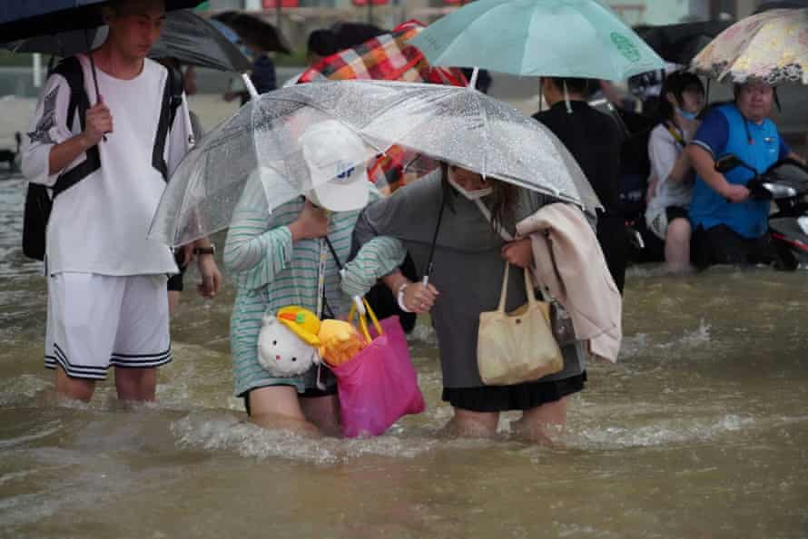Residents wade through floodwaters in Zhengzhou.