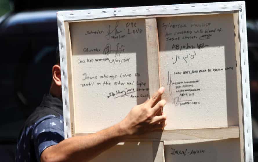 The writing at the back reads, “satu hati, satu rasa di dalam cinta” (one heart, one feeling in love), and is signed by the death-row inmates.