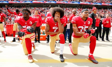 American football players Eli Harold, Colin Kaepernick and Eric Reid kneeling during the US national anthem to protest against police brutality