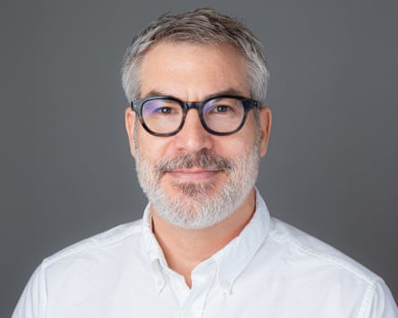 portrait of person wearing black glasses and white button-down