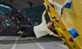 A man suspends himself perpendicularly on a climbing wall.