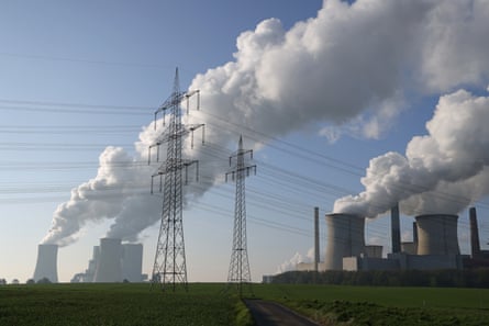 Electricity pylons stand as steam rises from cooling towers at the Neurath coal-fired power at Neurath, Germany
