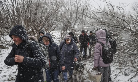 Civilians fleeing from Irpin as snow falls.