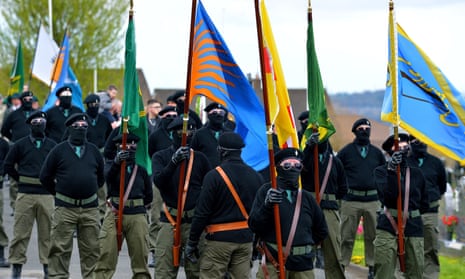 Masked men and women in paramilitary uniform parading at a dissident republican Easter Monday commemoration in Derry, Northern Ireland, last year.