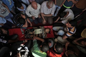 Palestinian mourners gather around the body of a man in Khan Yunis after he was killed during the protests at the Israel-Gaza border