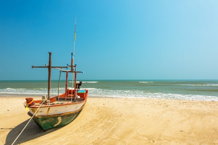 a boat marooned on an idyllic tropical beach