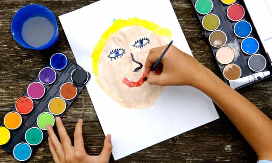 Child paints a face with water colours