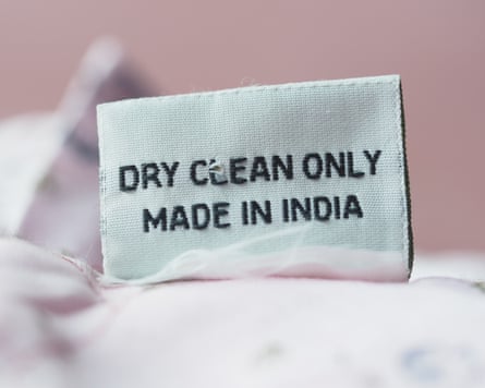 Dry clean only and made in India label on a light pink fabric