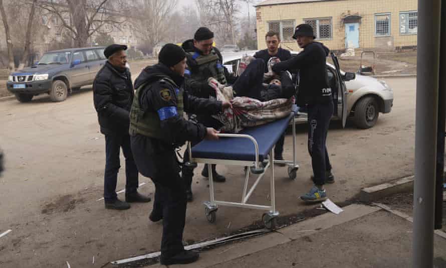 Ukrainian servicemen and volunteers carry a man injured during a shelling attack into hospital number 3 in Mariupol, Ukraine, 15 March