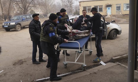 Ukrainian servicemen and volunteers carry a man injured during a shelling attack into hospital number 3 in Mariupol on Tuesday.