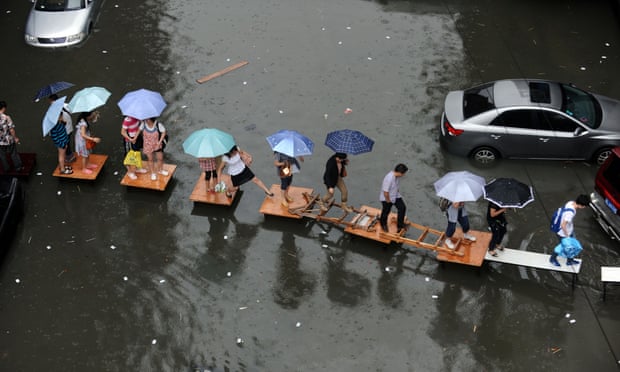 Wuhan residents cross a flooded street on a row of tables in 2012.