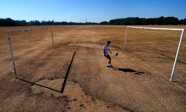 A boy plays football on the very dry pitches at Hackney Marshes in east London.