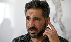 Ashraf al-Muhtaseb, a bearded man, holding up his hand as if making a point